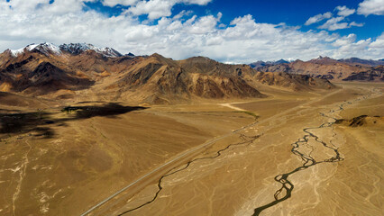 Aerial view of the Pamir Highway winding through the dramatic mountain landscapes of Tajikistan's Gorno-Badakhshan region breathtaking views of the Pamir Mountains  Central Asia's legendary Silk Road 