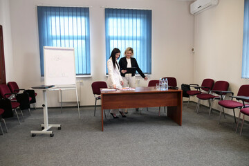 Two business women work in the office to solve problems and sign agreements.