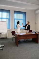 Two business women work in the office to solve problems and sign agreements.