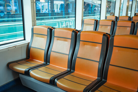Empty seats inside Istanbul ferry reflecting urban transit life. Interior of a public ferry boat in Istanbul, Turkey. Vibrant orange seats 