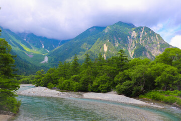 分厚い雲に覆われる山林と渓流