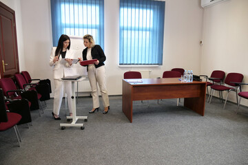 Two business women work in the office to solve problems and sign agreements.