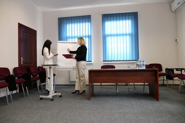 Two business women work in the office to solve problems and sign agreements.
