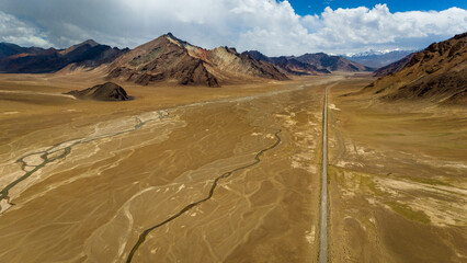 Aerial view of the Pamir Highway winding through the dramatic mountain landscapes of Tajikistan's Gorno-Badakhshan region breathtaking views of the Pamir Mountains  Central Asia's legendary Silk Road 