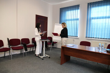 Two business women work in the office to solve problems and sign agreements.