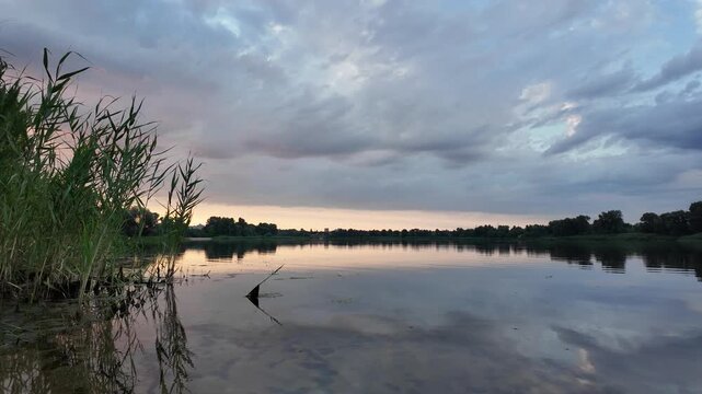 very beautiful sunset with water. summer evening landscape with reflection of clouds in water. setting sun on horizon. summer landscape with lake. reflection of trees in water. sunrise on river
