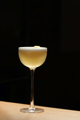 Elegant cocktail in coupe glass with orange peel and foam