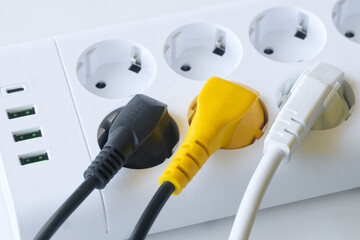 
High-angle shot capturing a white power strip with multiple European outlets and USB ports,...
