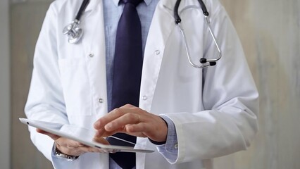 Doctor man wearing lab coat and stethoscope using tablet computer in hospital. Medicine and science