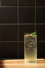 Highball cocktail with ice and mint in dramatic light
