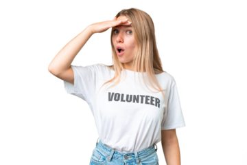 Young volunteer woman over isolated chroma key background doing surprise gesture while looking to the side