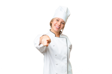 Young chef woman over isolated chroma key background points finger at you with a confident expression