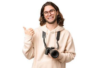 Young photographer man over isolated background pointing to the side to present a product