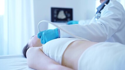 Doctor man with blue medical gloves is using ultrasound machine to examine neck of female patient...