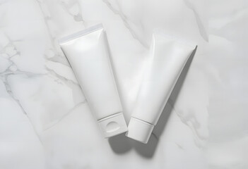 Two pristine, unbranded white cosmetic tubes stand side-by-side on a subtly textured white marble surface, ideal for product comparisons or sets.