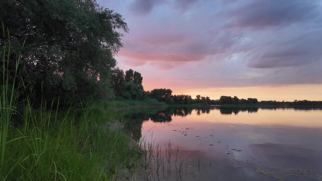very beautiful sunset with water. summer evening landscape with reflection of clouds in water. setting sun on horizon. summer landscape with lake. reflection of trees in water. sunrise on river