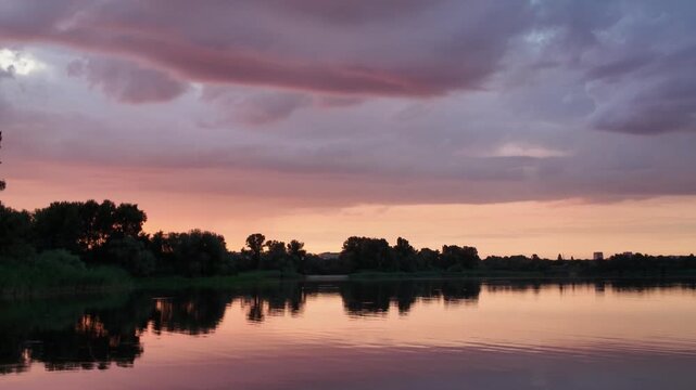 very beautiful sunset with water. summer evening landscape with reflection of clouds in water. setting sun on horizon. summer landscape with lake. reflection of trees in water. sunrise on river