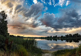 very beautiful sunset with water. summer evening landscape with reflection of clouds in water....