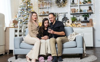 parents and Little girl with Christmas gifts near a Christmas tree at home
