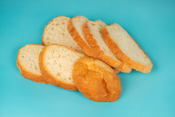 Neatly sliced white bread loaf arranged on a vivid blue background, showcasing soft texture and golden crust.