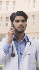 Vertical Photo of Sad Indian Doctor Talking on Phone Call