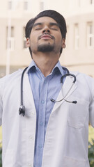 Vertical Photo of Indian Doctor Taking Deep Breath and Feeling Relaxed
