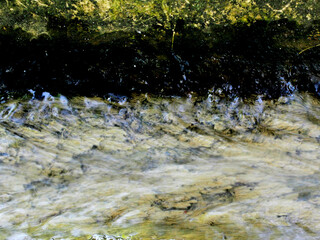 The water channel made of PVC pipe has been used for a long time and looks mossy.