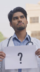 Question Mark, Vertical Photo of Cofused Indian Doctor Holding Question Mark Poster