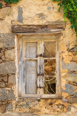 Old wooden window on rustic stone wall, France, Corsica, Cargèse, 15 June 2025
