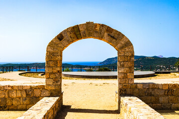 Stone arch with sea view and mountains, France, Corsica, Cargèse, 15 June 2025