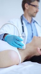 Doctor man wearing blue protective gloves is using ultrasound machine to examine neck of female...