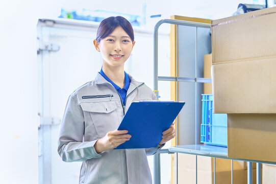 商品管理をする作業員の女性　工場　配送