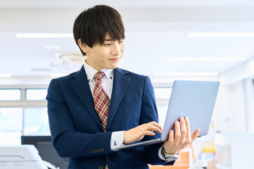 ノートパソコンを使うビジネスマン　オフィス　ビジネスシーン