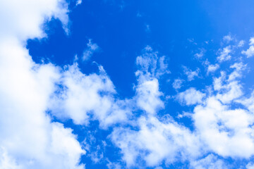 Clear blue sky with white fluffy clouds on a sunny day