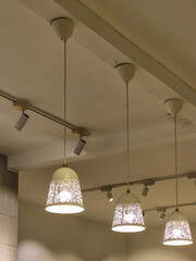 Three hanging pendant lights with intricate floral patterns glow warmly, suspended from the ceiling...