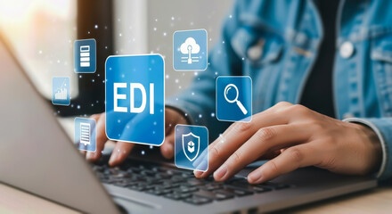 A person is typing on a laptop, with glowing icons representing electronic data interchange edi and various business functions floating around