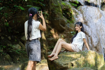Asian Indonesian Woman Taking Travel Photo at Waterfall in Yogyakarta