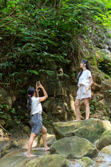 Asian Indonesian Woman Taking Travel Photo at Waterfall in Yogyakarta