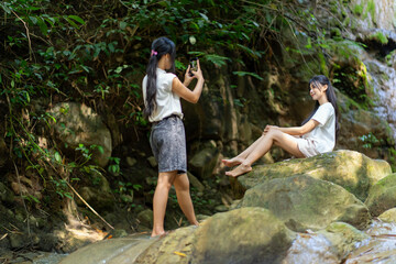 Asian Indonesian Woman Taking Travel Photo at Waterfall in Yogyakarta