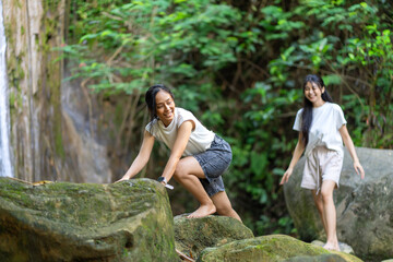 Asian Indonesian Women Trekking Barefoot by River Rocks in Yogyakarta Jungle