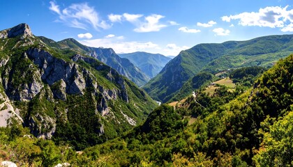 Naklejka premium Dramatic mountain landscape with lush forests and rocky peaks under a blue sky