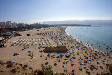 Obraz premium View of Praia da Rocha beach in Portimão, Algarve, Portugal. Golden sand, dramatic cliffs and blue Atlantic ocean under a clear summer sky.