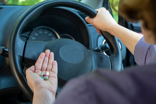 Pills in the hand or on the palm of the driver. The use of pharmacological drugs for medical purposes while driving.