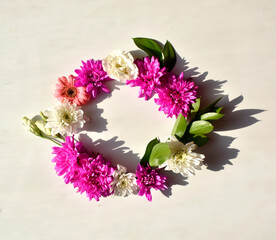 Round flower frame made of pink and white flowers, leaves and buds isolated on white background. Copy space.