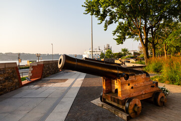 Closeup of a cannon on the 17th Century Royal Battery patrimonial site seen in early morning in the old town, with the St. Lawrence river in the background, Quebec City, Quebec, Canada