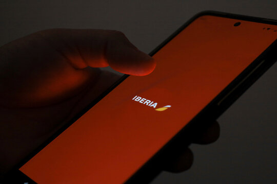 Person using Iberia flight booking application on mobile phone