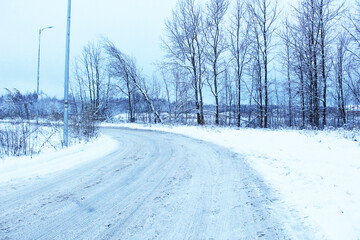The road in the snow is serpentine in the evening at dusk. Winter Landscape
