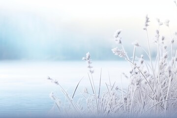 Obraz premium Stunning winter scene with frozen grass blades by a serene lake, creating a tranquil and ethereal atmosphere