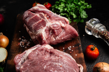 Raw pork neck on a wooden board on the table