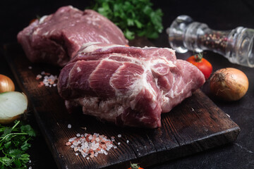 Raw pork neck on a wooden board on the table